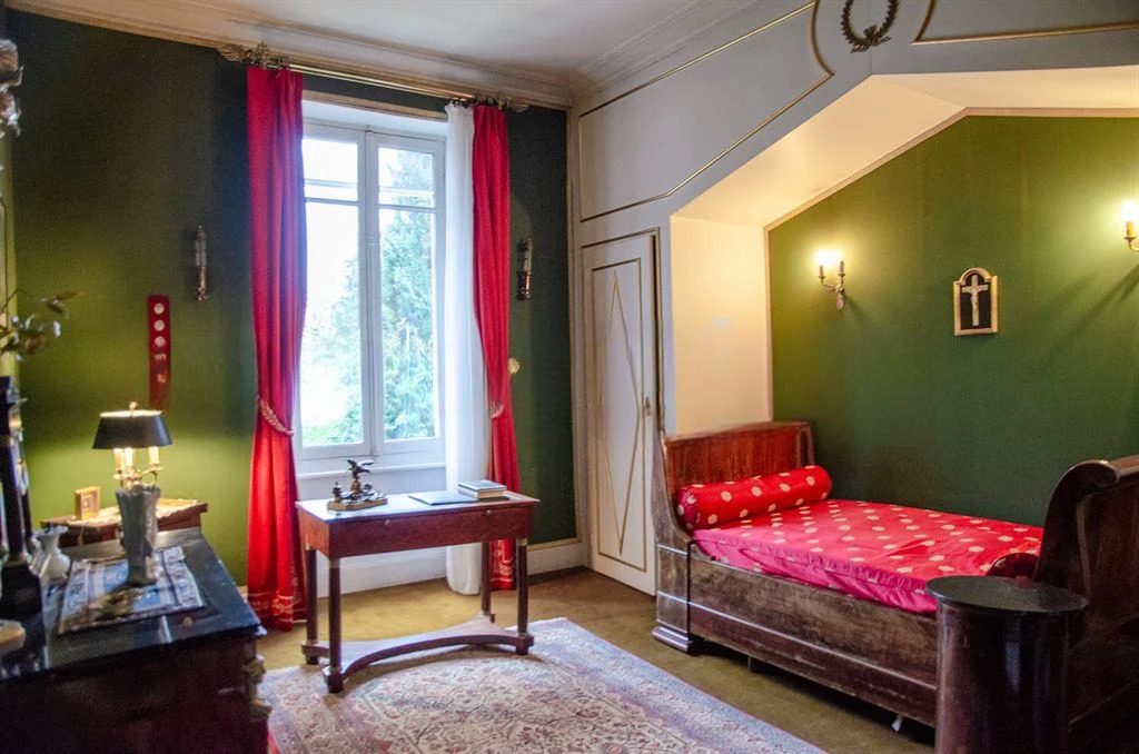 Chambre verte avec secrétaire, méridienne et rideaux rouges
