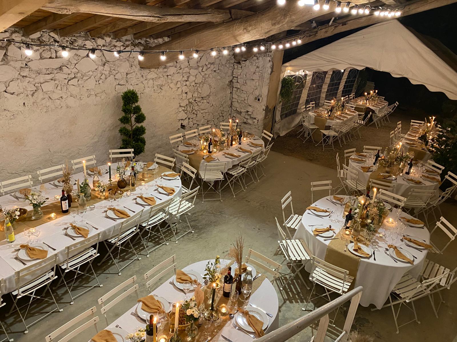 Tables dressées aux bougies pour un dîner de mariage en soirée dans le Tarn - ambiance chaleureuse et guirlandes lumineuses